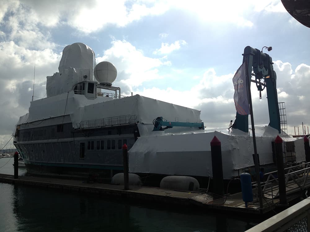 Shrinkwrapped yacht undergoing maintenance at a shipyard in Auckland
